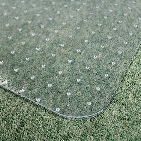 Tapis de protection de sol transparent sur moquette verte. Des goujons ronds sous le tapis le maintiennent en place.