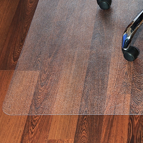 Tapis de bureau transparent pour chaise de bureau sur plancher en bois, un pied de chaise avec roulette est visible.