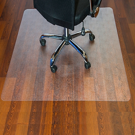 Tapis de chaise de bureau transparent sur plancher en bois. Une chaise est dessus.