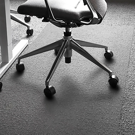 Chaise de bureau à roulettes sur un tapis gris, tapis dans le coin