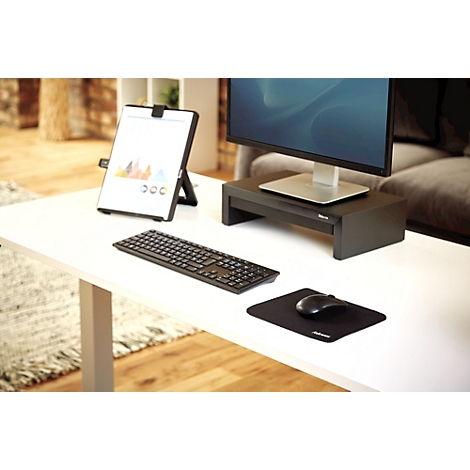 Main sur une souris noire avec tapis de souris.