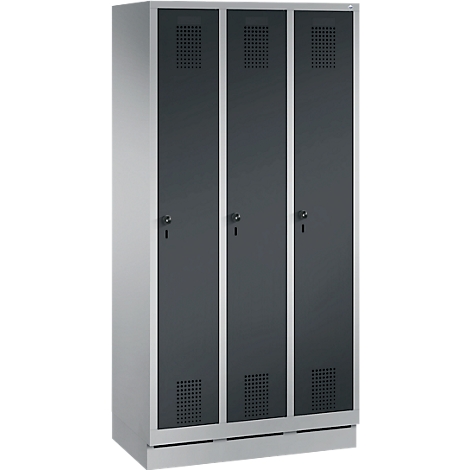 Taquilla gris con tres puertas, cada una con ranuras de ventilación y cerradura. Las puertas están separadas por tiras plateadas.