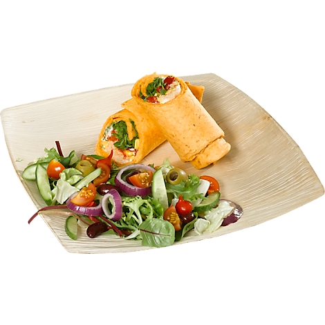 Zwei gefüllte Wraps auf einem Teller, daneben ein Salat. Die Wraps sind mit Gemüse gefüllt, der Salat mit Tomaten und Oliven.
