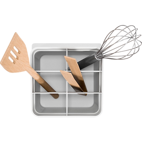 Vue de dessus d'ustensiles de cuisine dans un support gris: fouet, spatule et pinces en bois.