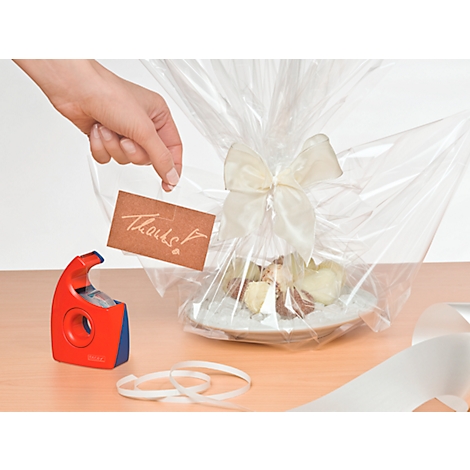 Gift wrapped in foil with bow. A thank you card is being attached.