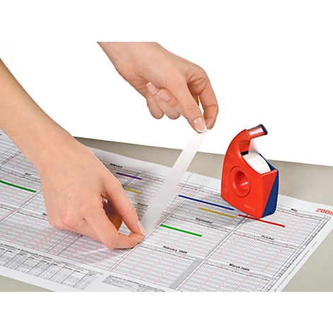 Hands applying tape on a calendar. Red and blue tape dispenser on the right.