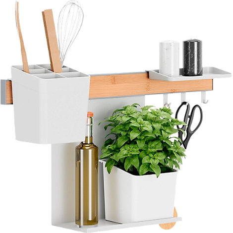 Küchenleiste mit Utensilien, Kräutern und Gewürzen. Enthält einen Topf mit Basilikum, eine Ölflasche, und Küchenhelfer.