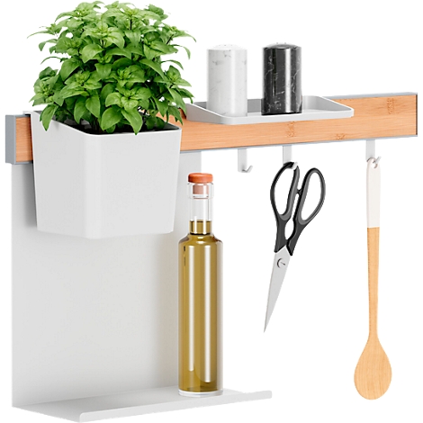 Étagère de cuisine avec pot d'herbes, épices, ciseaux, bouteille d'huile et cuillère en bois. Éléments blancs, fond.