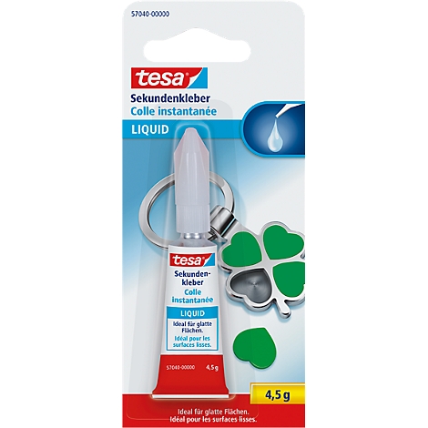 Close-up of a tube of Tesa super glue with a clover-shaped key ring. The glue has a red and white hue, with German and French inscriptions.