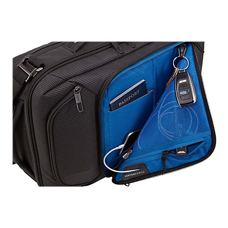 Schwarze Aktentasche mit blauer Innenseite. Innen: Reisepass, Schlüssel, Handy, Ladekabel.