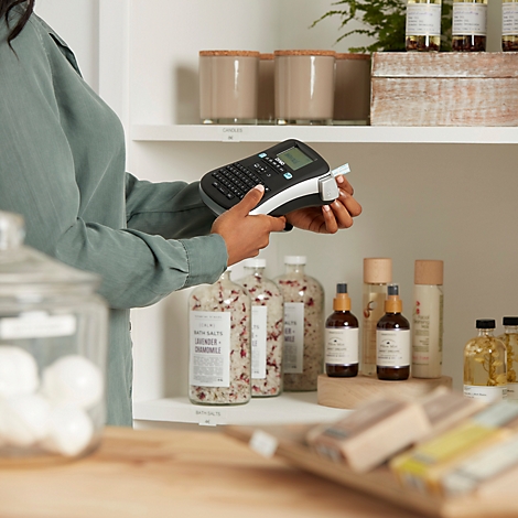 Une personne utilise une étiqueteuse portable pour créer des étiquettes pour des produits dans un magasin.