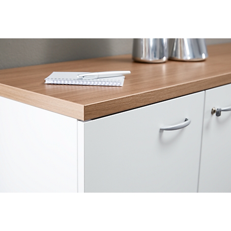 Close-up of white sideboard with wooden surface, on it notepad, pen and metal vases.