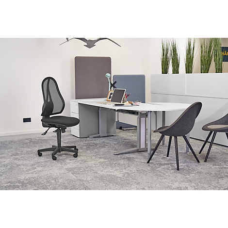 Office chair in front of desk, grey carpet and grey wall. In the background are more chairs, plants and decor.