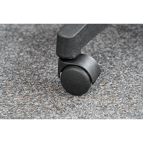 Close-up of a chair wheel standing on gray carpet. The wheel is black and has a round shape.