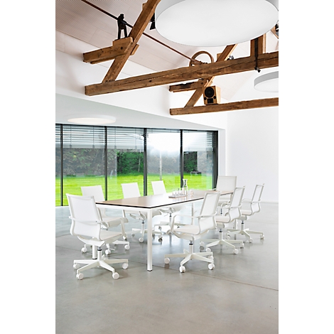Bright conference room with long table and white chairs, wooden beams, large windows overlooking greenery.