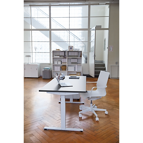 Office with desk, laptop, and chair. Large windows with a view of a staircase.
