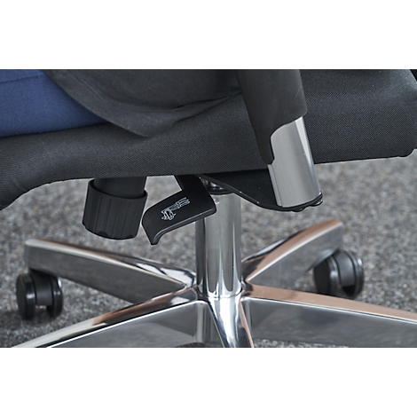 Close-up of chair: lever, chrome frame and fabric seat cover. Part of the person is visible in the picture.