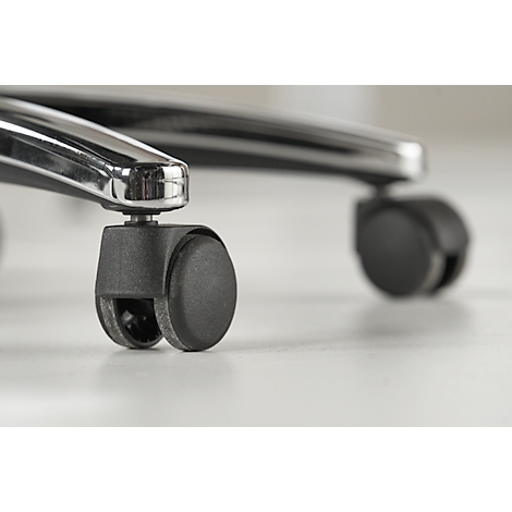 Close-up of black chair casters on a light surface. Chrome struts are visible.