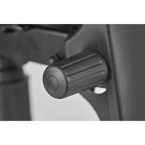 Close-up of a black knob on an office chair. The knob has ribbed sides and a round, slightly recessed center.