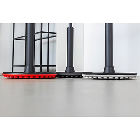 Three chair legs with colored bases, red, black, and white. The floor reflects the light.