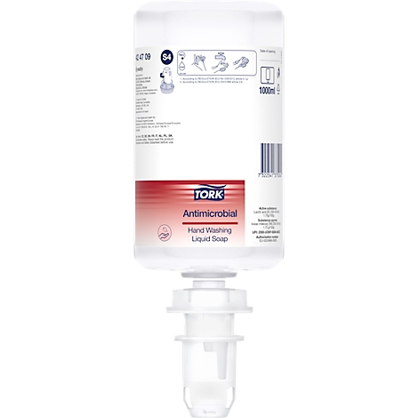 Distributeur de savon blanc avec une étiquette rouge et bleue, "TORK Antimicrobien".
