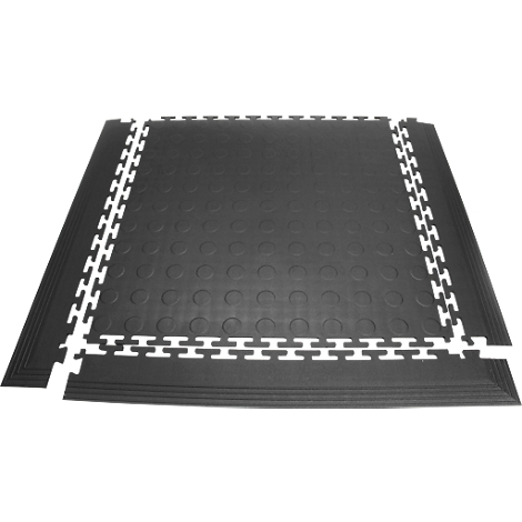 Black rubber floor tiles with white tooth edges forming a rectangle. A few pieces can also be seen on the edge.