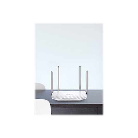 WeiÃŸer WLAN-Router mit vier Antennen auf einem Tisch. Das GerÃ¤t steht vor hellem Hintergrund.