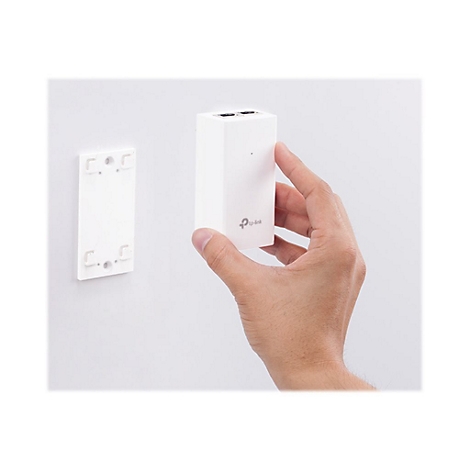 Person hÃ¤lt ein weiÃŸes, rechteckiges GerÃ¤t vor einer Wand. Links daneben eine weiÃŸe Halterung. Auf dem GerÃ¤t ist das TP-Link-Logo zu sehen.