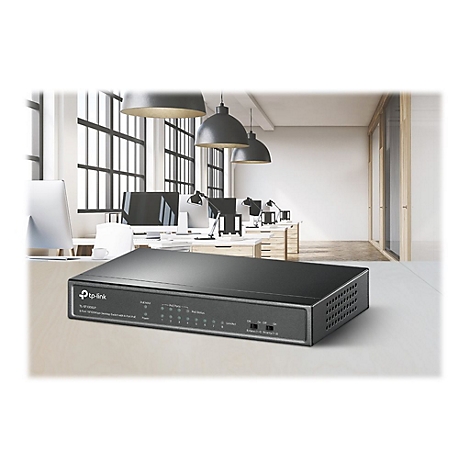 Ein schwarzer TP-Link-Switch liegt auf einem Tisch in einem BÃ¼roraum, im Hintergrund Schreibtische und Fenster.