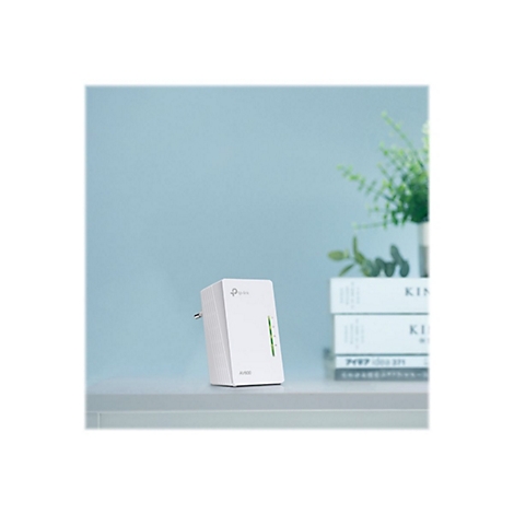 Ein weißes TP-Link AV600-Gerät auf einem Tisch, vor einer hellblauen Wand. Im Hintergrund ein Blumentopf.