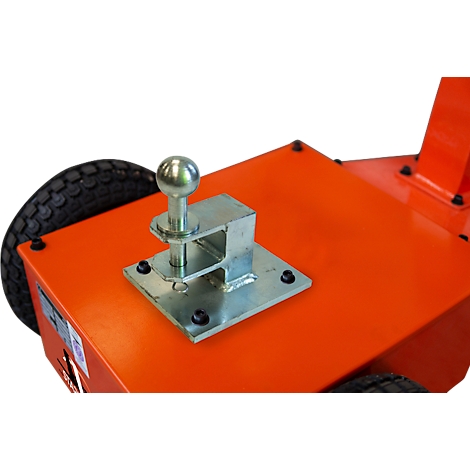 Gros plan : Attelage de remorque avec boule argentée sur surface orange.