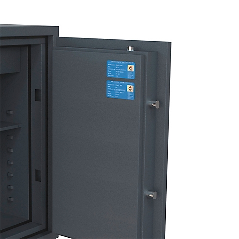 Geöffnete Tür eines dunkelgrauen Stahlsafes mit zwei blauen Informationsaufklebern an der Innenseite.