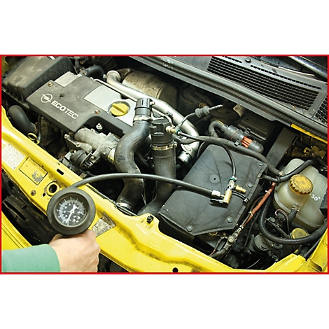 Nahaufnahme eines Motorraums mit Werkzeug. Eine Hand hält ein Manometer. Deutlich sichtbar ist der Motor mit ECOTEC-Schriftzug.