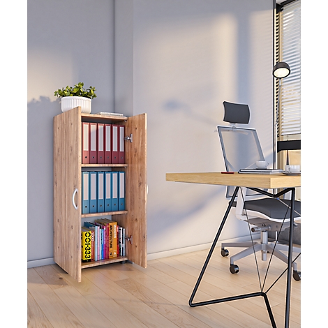 Open filing cabinet with folders and books. Desk with laptop and chair in the background.