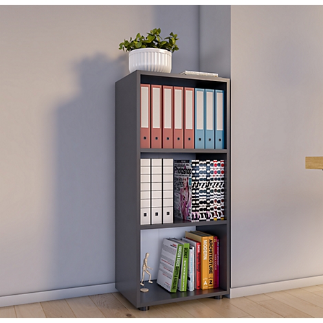 Gray bookshelf with plants, file folders, and books standing against a gray wall.
