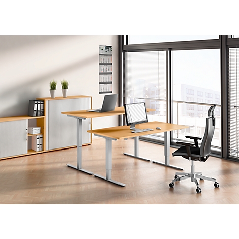 Office interior with desk, chair, laptop and monitors. Bright office setup with sliding door cabinet and window.