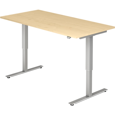 A light brown rectangular desk with gray, height-adjustable legs. The desk is isolated.