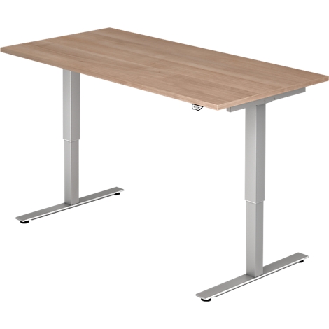 An adjustable height desk with a wooden top and silver legs. The legs are T-shaped.
