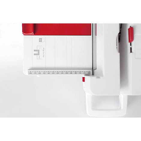 Detail shot of a white paper cutter with red accent. A ruler in cm is visible.