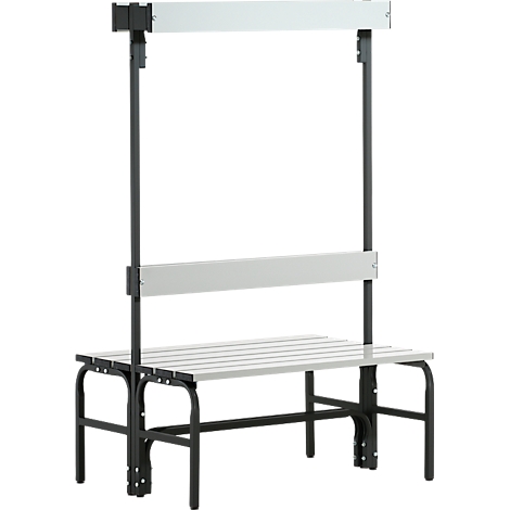 Grau-schwarze Sitzbank mit Rücklehne und einem Überbau. Gestell aus schwarzen Metallrohren, Sitzfläche aus grauen Leisten.