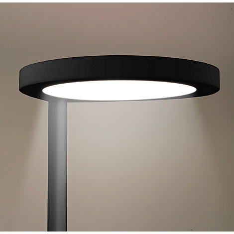 Un éclairage extérieur moderne et rond avec un cadre noir et une lumière vive, sur un poteau gris.