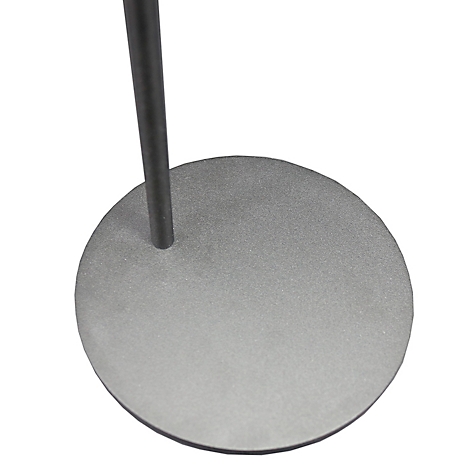 Gros plan sur la base ronde et grise d'un pied de microphone avec le pied.