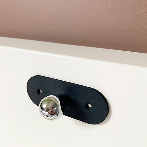 Bouton de meuble noir avec sphère chromée sur fond blanc.