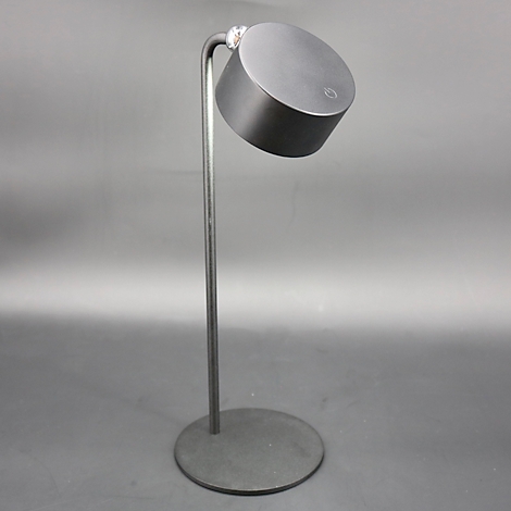 Een moderne, antracietkleurige staande lamp met een ronde voet en een cilindrische kop, gekanteld.