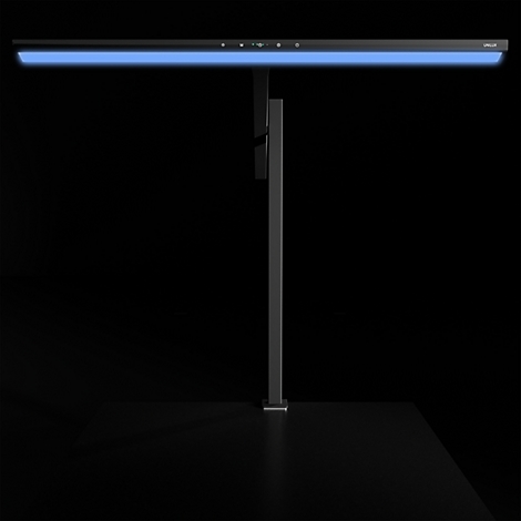 Moderne, schlanke Schreibtischleuchte mit blau leuchtendem Lichtbalken vor schwarzem Hintergrund.