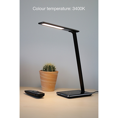 Schwarze LED-Schreibtischlampe leuchtet auf einem Holztisch neben einem Kaktus im Tontopf. Text: Colour temperature: 3400K.