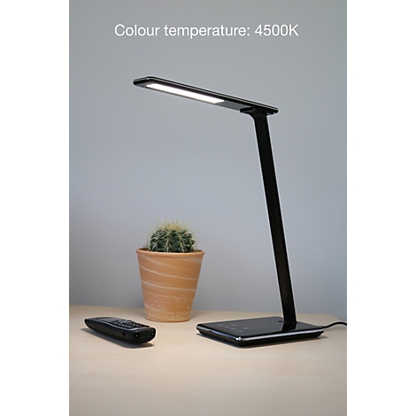 Schwarze LED-Schreibtischlampe mit einer Farbtemperatur von 4500K auf einem Holztisch neben einem Kaktus.