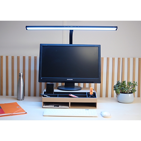 Schreibtisch-Setup mit Monitorständer aus Holz, Bildschirm und aktiver Monitorlampe.