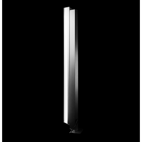 Eine schlanke, silberne Stehlampe vor schwarzem Hintergrund.