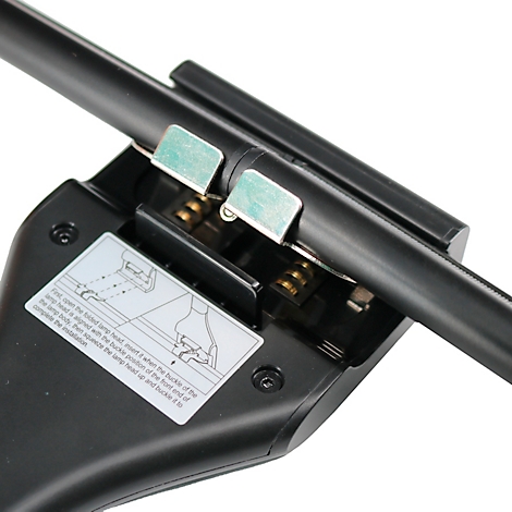 Close-up: Zwart apparaat met metalen clips, instructielabel en een zwarte buis.